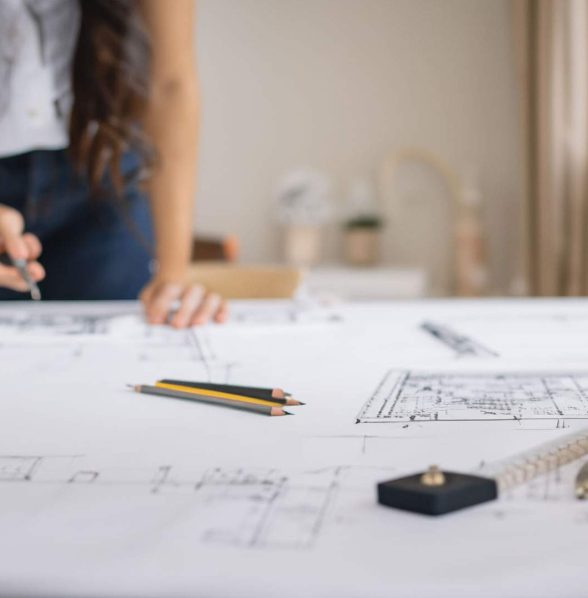 Architetto che disegna planimetria per relazione tecnica di vendita immobiliare